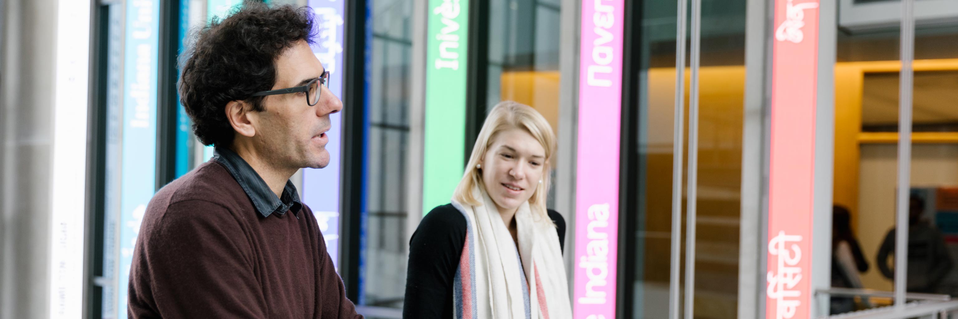 Two people conversing int he Global and International Studies Building 