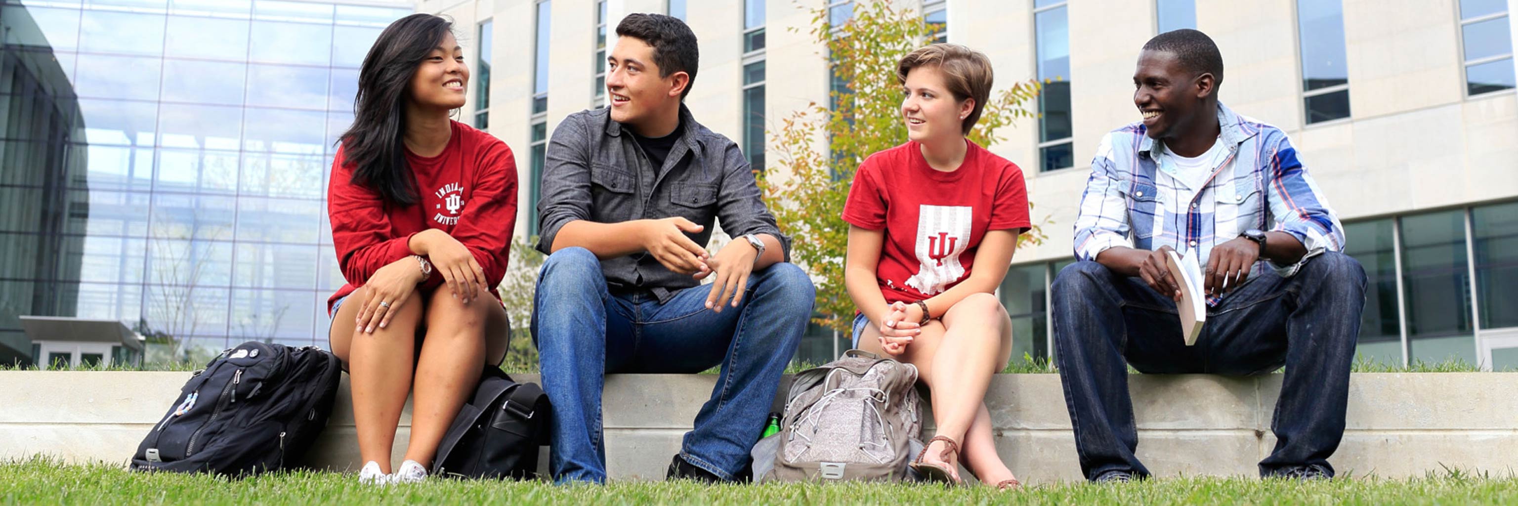 Students talking with one another as they sit in front of Global and International Studies Building