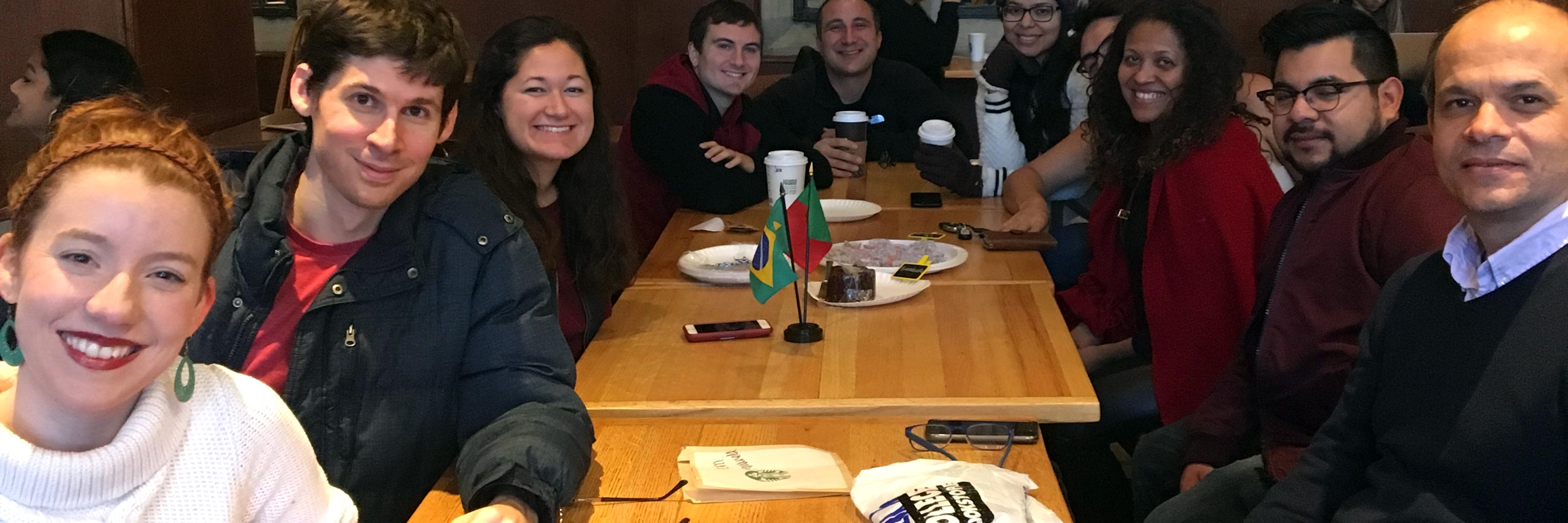 Members of the Spanish and Portuguese department sitting around a large table and smiling for the camera