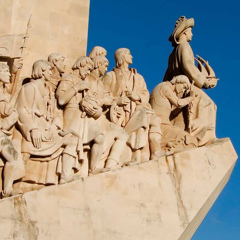 Statue of a man on ledge holding a boat followed by people