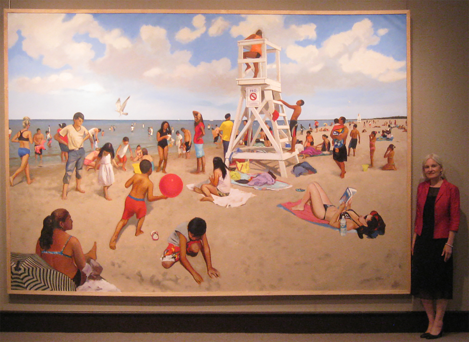 Portrait of Ann Walls Ponce with painting at gallery.