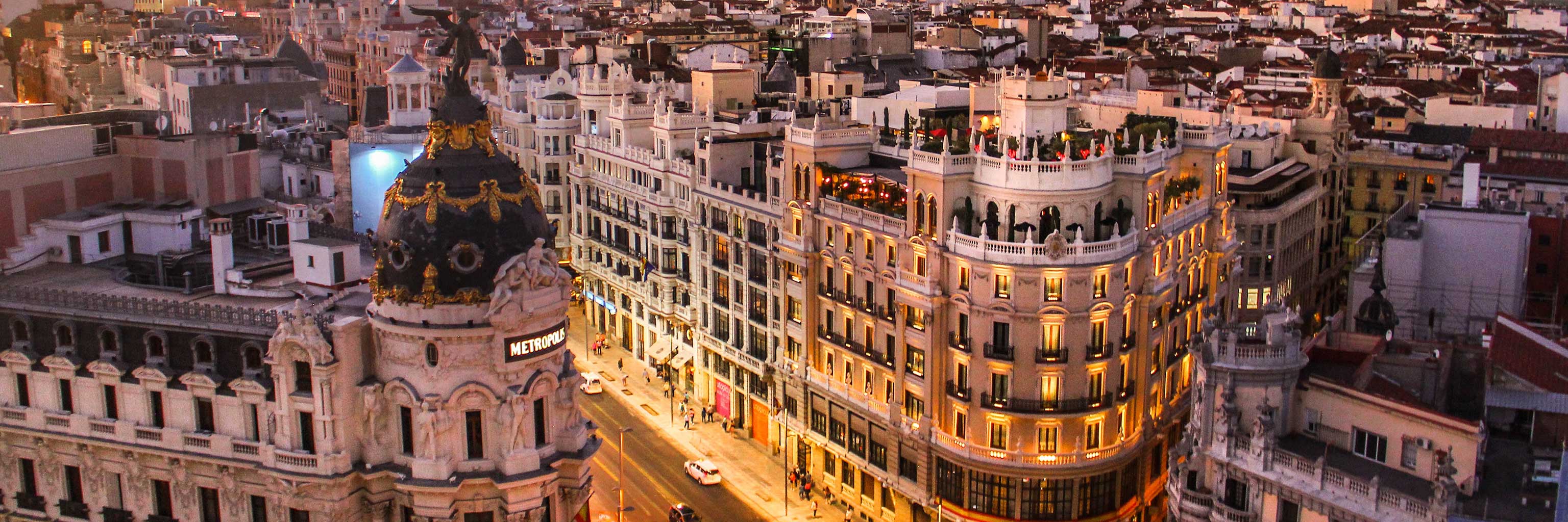 A high-angle shot of the streets of Madrid, which glow golden beneath the setting sun.