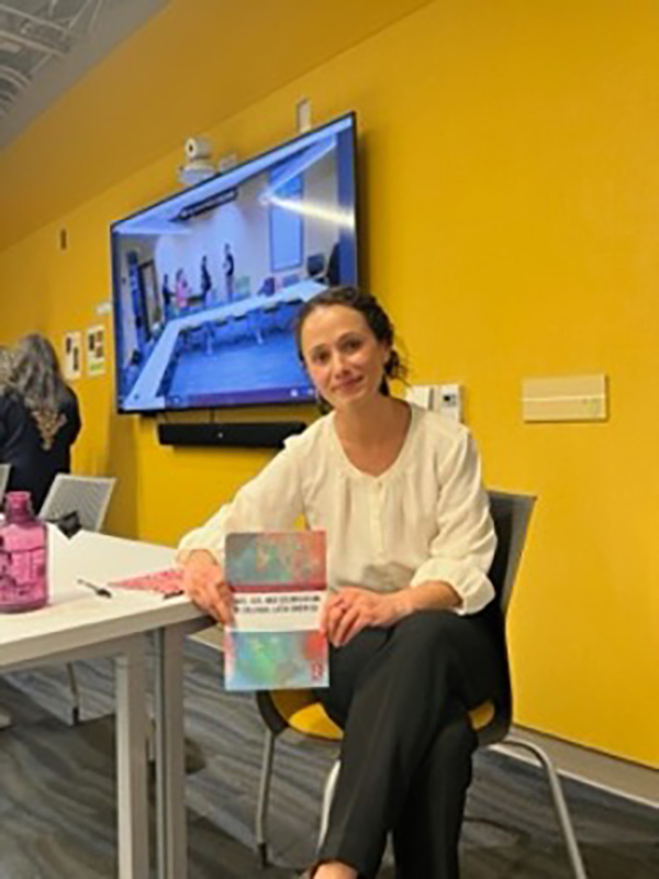 Olimpia Rosenthal poses with her book at an event.