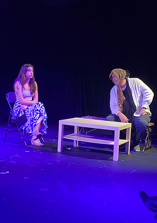 Two people in a costume perform together on a stage.